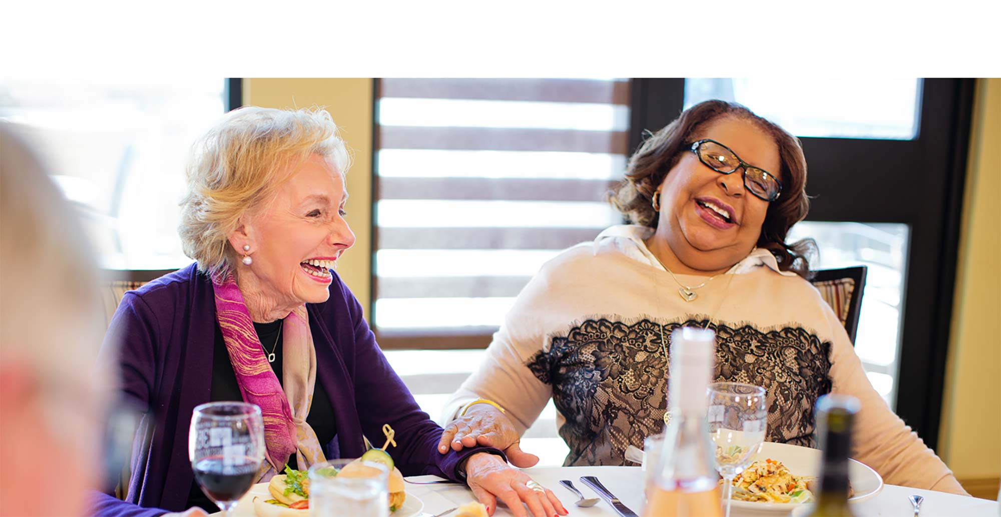 Two women laughing at Kingswood Senior Living Located in Kansas City, MO.