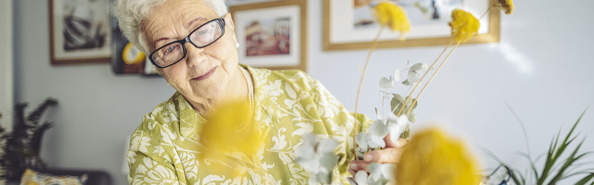 A women arranging flowers at Kingswood Senior Living Located in Kansas City, MO.